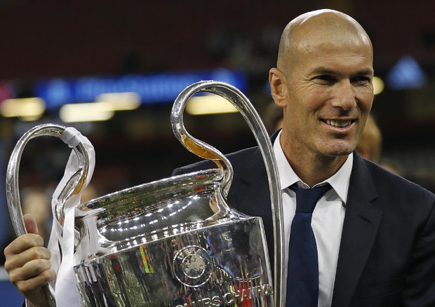 Zidane mostra sorridente la Coppa della Champions.