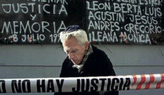 Un anziano in preghiera davanti al luogo dell'attentato con la scritta "No Hay Justicia"
