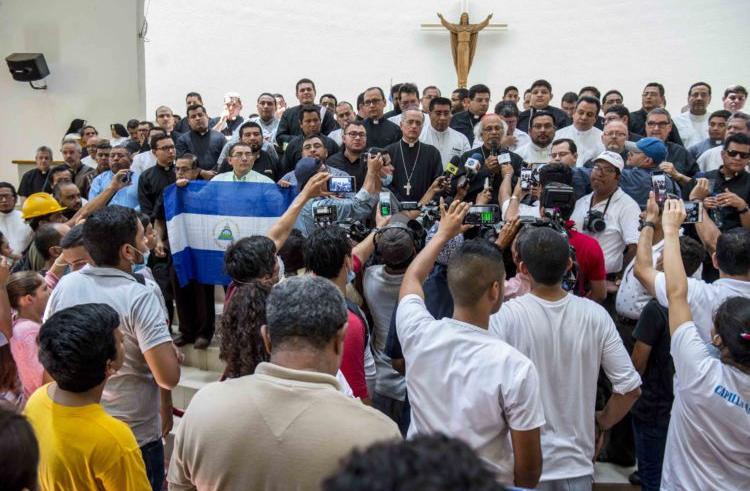 Gruppo di manifestanti che protestano contro il Noriega alzando la bandiera del Nicaragua, tra loro dei prelati.