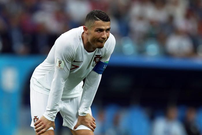 Cristiano Ronaldo con la casacca della nazionale del Portogallo durante il mondiale Russia 2018, mentre prende fiato con le mani appoggiate alle ginocchia.