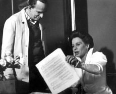 Ingmar Bergman in piedi e Ingrid Thulin seduta con dei fogli in mano, durante la lavorazione del film "Whispers and calls"