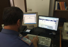 Funzionario della Polizia al computer investigando il caso