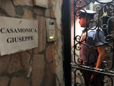 Un momento della maxioperazione dei carabinieri: Il portone-cancello della casa con la lapide "Giuseppe Casamonica"