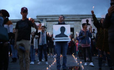 Manifestazione notturna con candele e foto dei leader sindacali uccisi