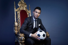 Cristiano Ronaldo seduto su un trono con un pallone in mano. CR7