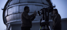 Due persone si preparano a guardare l'eclisse dalla parte esterna di un osservatorio