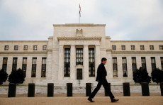 Un uomo camminando davanti alla sede della Fed a Washington