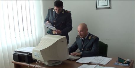 Ufficiali della Guardia di Finanza al lavoro davanti al computer