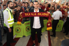 Javier Pastore al suo arrivo a Roma mostra la sciarpa dei tifosi giallorossi con la scritta "Io ci sono"