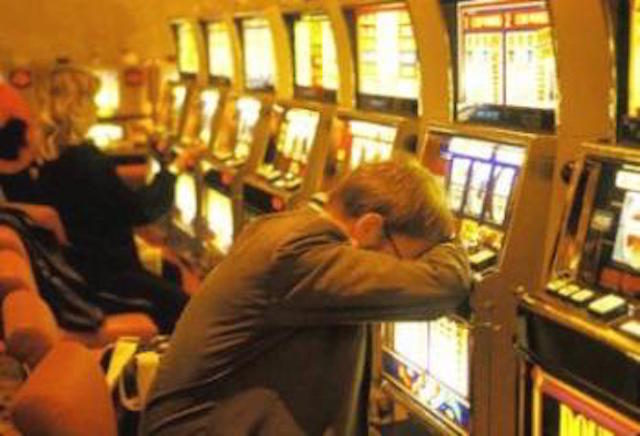 Giocatore con la testa appoggiata alle slot-machine