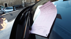 Una multa inserita sotto il tergicristallo di un'auto.