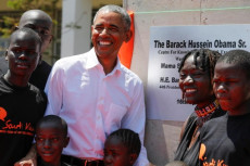 Obama con un gruppo di ragazzi africani davanti ad una targa in suo ricordo.