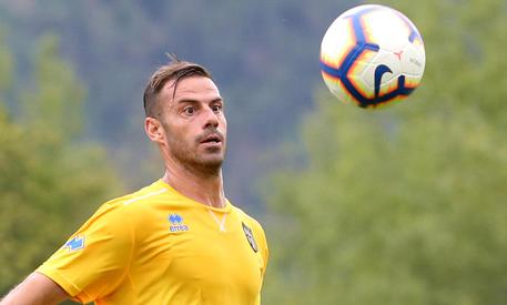 L'attaccante del Parma, Emanuele Calaio', durante la prima amichevole della stagione, maglietta gialla e pallone di fronte.