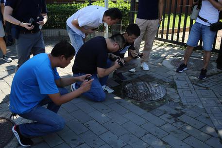 Reporters filmano e scattano foto sul luogo dell'esplosione della bomba a Beijing