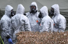 Militari con tute protettive bianche sul luogo del ritrovamento del veleno.