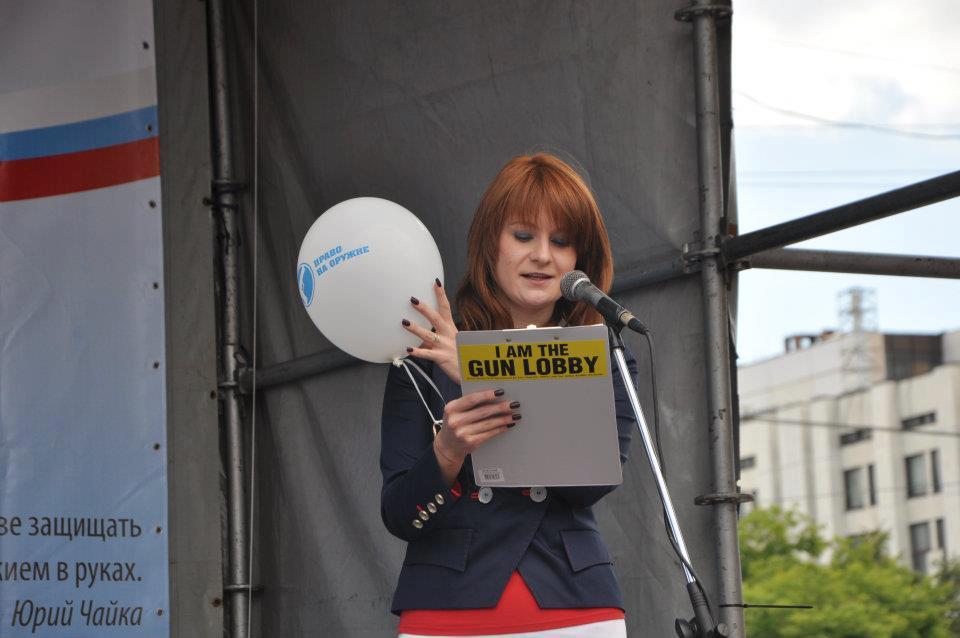 Una donna dai capelli rossi, mentre legge un documento davanti un microfono.