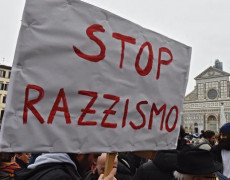 Manifestazione contro il razzismo con un cartellone con la scritta "STOP RAZZISMO"