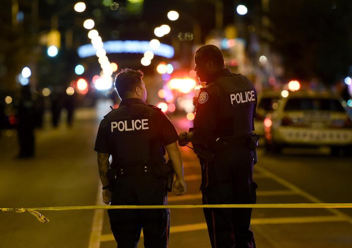 Due poliziotti ripresi de spalle sulla zona dell'attentato a Toronto.