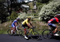 La maglia gialla, il belga Greg Van Avermaet, sui tornanti alpini, con due gregari.