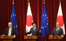 Donald Tusk e Jean-Claude Juncker, ai lati del premier giapponese Shinzo Abe dopo la firma dell'accordo. Alle loro spalle la bandiera giapponese e quella europea.