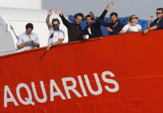 Migranti salutano dal bordo dell'Aquarius.