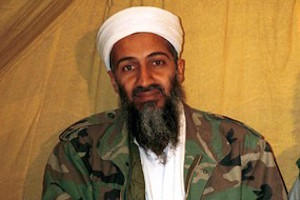 Un primo piano di Osama Bin Laden con turbante bianco e barba lunga.