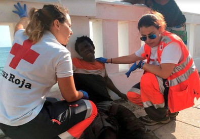 Due agenti donne assistono un migrante semi-svenuto