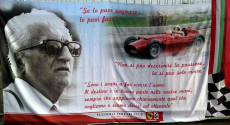 Un poster di Enzo Ferrari con una sua foto e alcune sue frasi famose