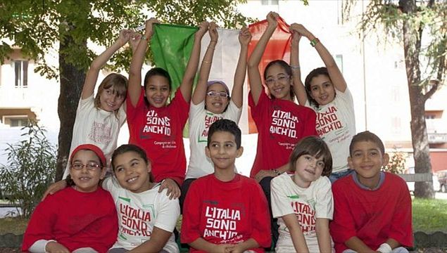 Un gruppo di ragazzi nati in Italia ma figli di immigrati, sventolano la bandiera italiana.