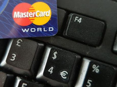 Una carta di credito MasterCard appoggiata sulla tastiera di un computer.