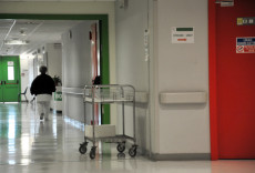Sanità: corridoio di ospedale con infermiera e carrello.
