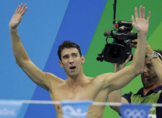 Michael Phelps alza le braccia in segno di vittoria dopo una gara alle Olimpiadi di Rio.