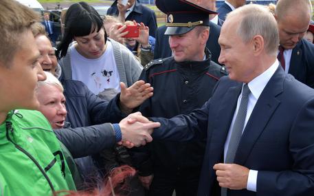 Putin stringe le mani dei suoi sostenitori.