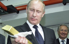 Putin grada un lingotto d'oro che ha in mano