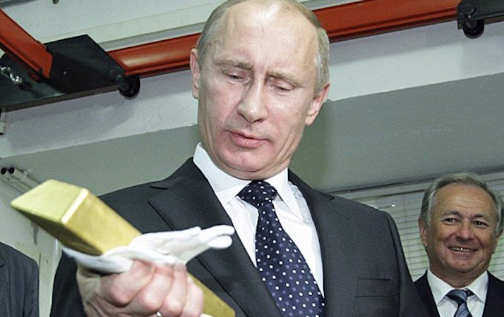 Putin grada un lingotto d'oro che ha in mano