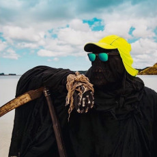 Una persona nera in spiaggia con un cappello giallo