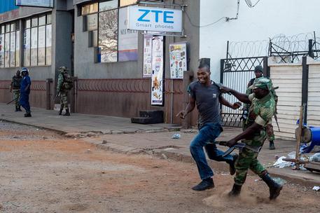 Una persona, sospettata di protestare, viene inseguita dai militari in Zimbabwe