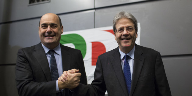 Nicola Zingaretti e Paolo Gentiloni si stringono la mano di fronte al cartellone con il simbolo del Pd