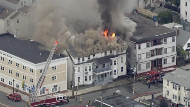 Un palazzo avvolto dal fumo dell'incendio mentre intervengono i pompieri. Boston