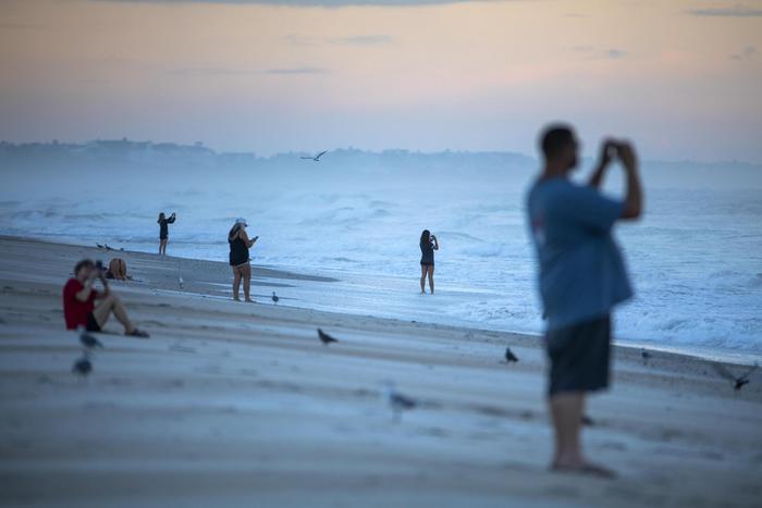 Americani su una spiaggia del North Carolina fotografano l'arrivo di Florence