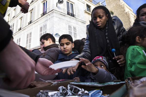 Volontari distribuiscono regali a bambini poveri francesi. Povertà