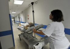 Infermieri in servizio con una lettiga in corridoio ospedale.
