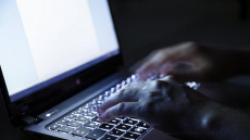 Le mani di un hacker sulla tastiera di un computer, inviando Mail con iban ritoccato