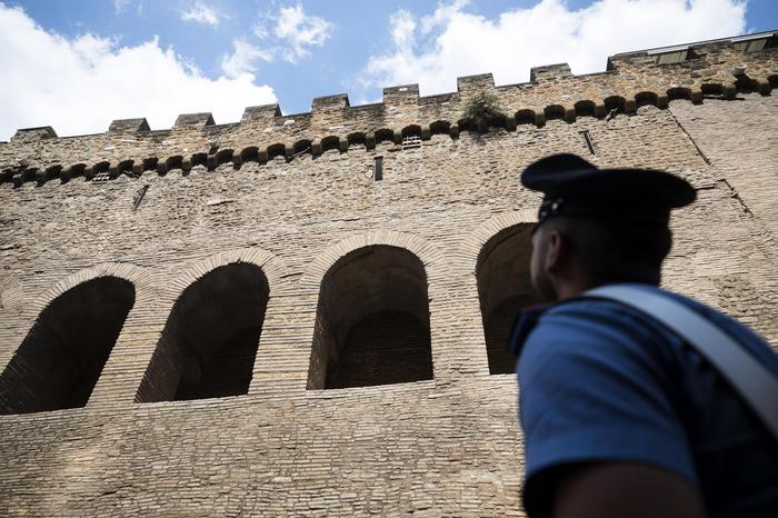 Un carabiniere guarda verso l'alto dove è avvenuto il distacco di frammenti dalle mura del 'Passetto' di Borgo