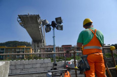 Operai al lavoro sui binari della ferrovia danneggiati dal crollo di Ponte Morandi. Sfollati