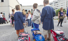 Tre bambini con i loro zainetti pronti ad entrare alla scuola elementare Carlo Levi per il primo giorno di scuola