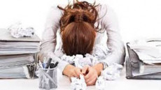 Una donna con la testa appoggiata sul tavolo, stress