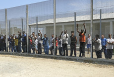 Migranti dietro le reti nel centro d'accoglienza a Capo Rizzuto.