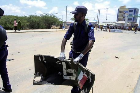 Un ufficiale della sicurezza della Somalia con la portiera del mezzo distrutto.