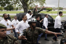 Bolsonaro scortato dai suoi uomini si dirige al suo seggio.